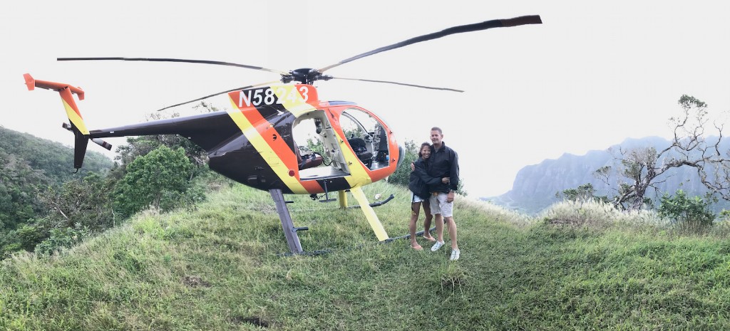 Scott Magner and his wife on a hillside next to a helicopter