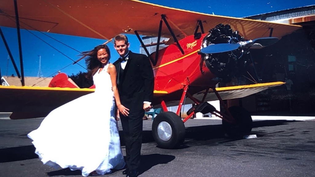 Scott Magner and his wife in wedding clothes beside a red biplane
